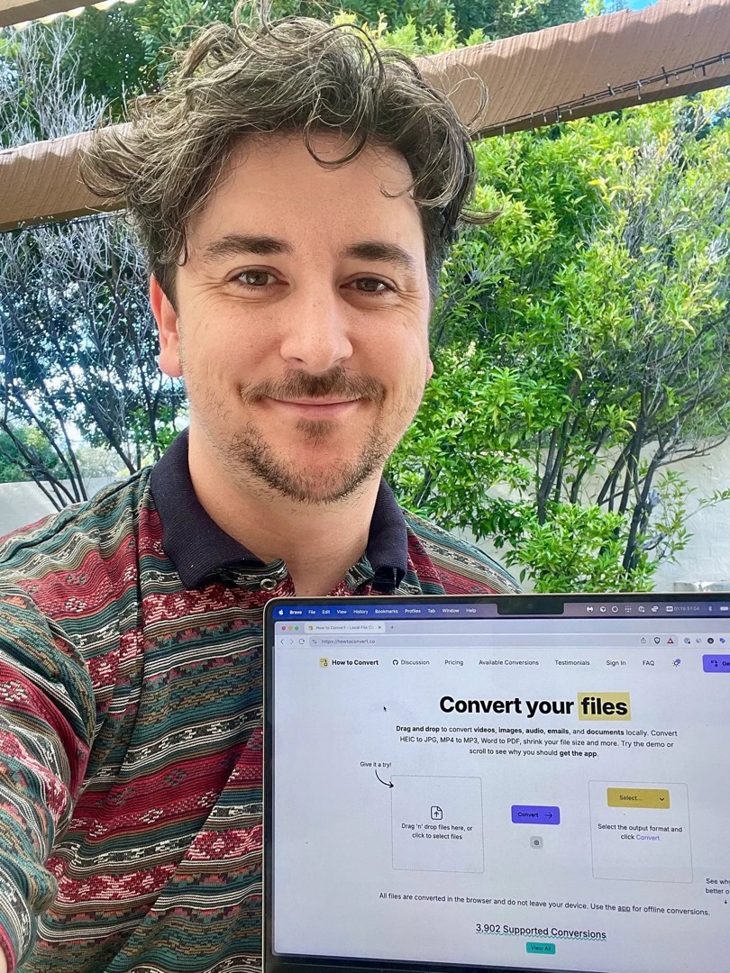 Jake outside with How to Convert open on his laptop